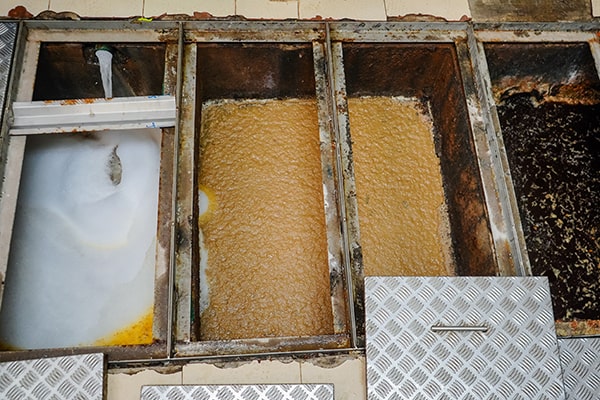 grease trap maintenance involves pumping out accumulated grease, scraping down the walls, and inspecting for any issues